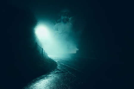 A ghostly statue of a graveyard angel. Floating over on an atmospheric foggy winters night.の写真素材