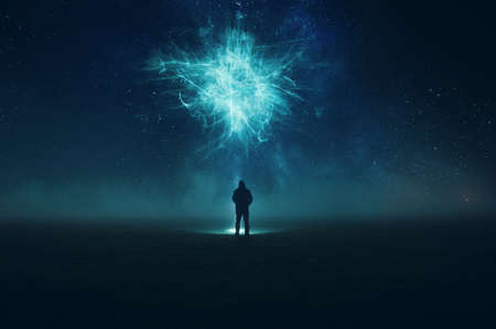 A spooky alien encounter. Of a man silhouetted against the night sky, holding a torch, looking up at a floating alien cloud. With an abstract, artistic, editの写真素材