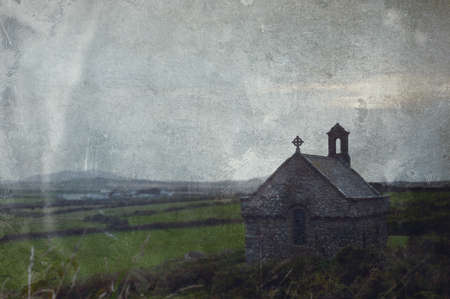 An atmospheric moody, isolated chapel overlooking fields and the countryside. With a vintage, grunge...