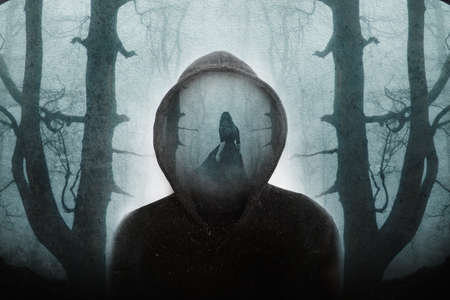 A supernatural concept of a double exposure of a ghostly woman wearing a long dress, walking through a spooky, foggy forest. Over layered on a hooded figure in winter. With a grunge, vintage edit.の写真素材