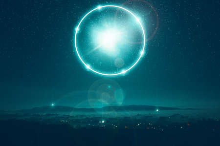 A science fiction concept of a glowing portal floating above the countryside. On a misty spooky...