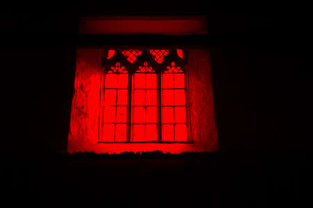 A horror concept of a spooky church window. With a red, black moody edit.