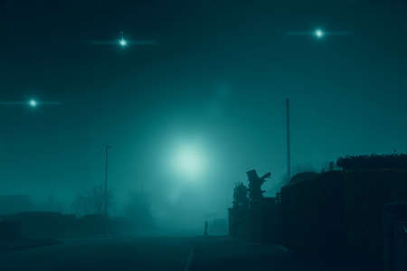 Glowing UFO lights in the sky. In a quiet empty road in a suburban town. On a quiet, atmospheric foggy winters day. UKの写真素材