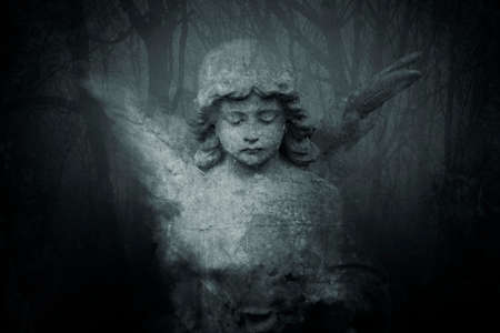 A spooky statue of a graveyard angel with wings representing grief and death. With a grunge, texture.の写真素材