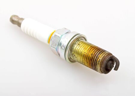 Close-up old burned spark plug on white background