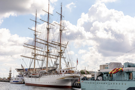 Tourists walk around the marina near sailing ship Dar Pomorza (Gdynia, Poland)