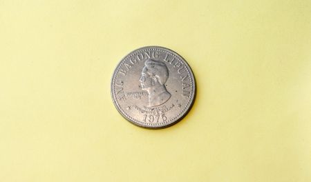 Old vintage coin circa 1972 depicting the face of Ferdinand Marcos 1972 - in a yellow backgroundの写真素材