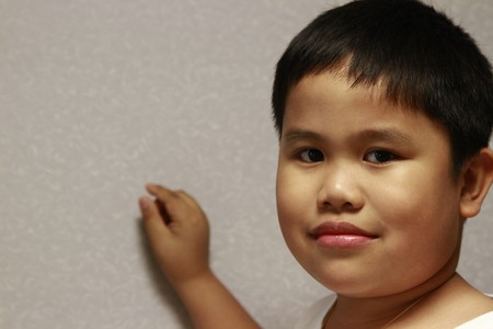 Young filipino boy with hand in the backgound.の写真素材