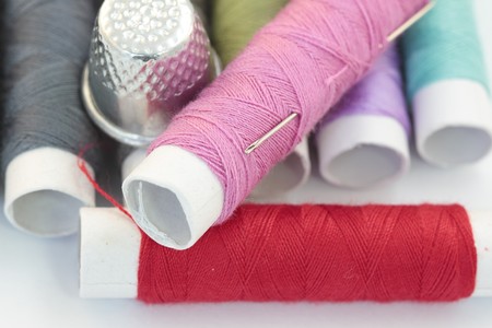 Needle and thread of different colors and timble.