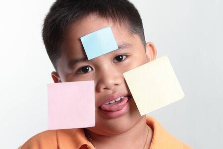 Boy's funny face with blank note for your messageの写真素材