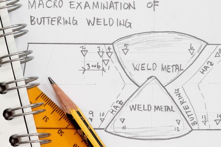 Weld symbol as shown in a drawing paper with spiral notebook and pencil.