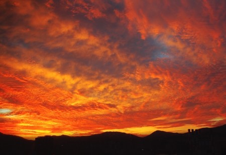 Dramatic colors of sunset sky with mountains in the backgroundの写真素材