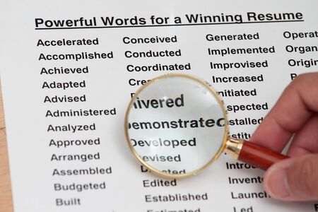 Powerful word for winning a resume- magnifying glass searching for powerful wordの写真素材
