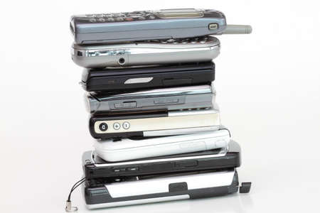 Pile of cell phones on white background - removed the logos.