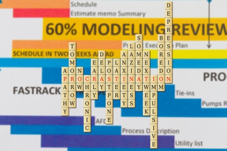 procrastination in a word puzzle with schedule background.の写真素材