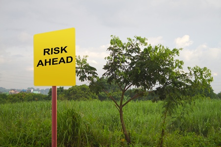 Picture of yellow road sign warning about risk ahead の写真素材