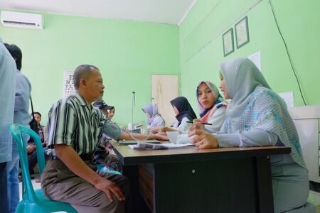 Purbalingga, Indonesia - July 30, 2019: Old man having medical check up before renewal driver licenseのeditorial素材