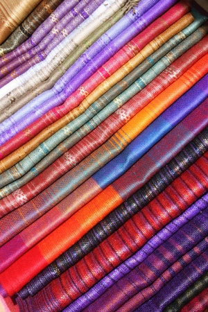 Colorful stacked linens woven from alpaca wool available for sale at the outdoor craft market in Otavalo, Ecuadorの写真素材