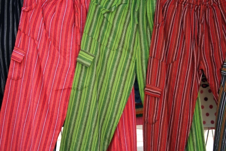 Handmade striped pants in a variety of colors hang for sale at the outdoor craft market in Cotacachi, Ecuadorの写真素材
