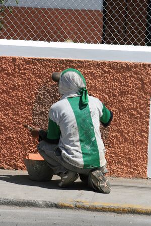 A man painting a wall in Cotacachi, Ecuadorの写真素材