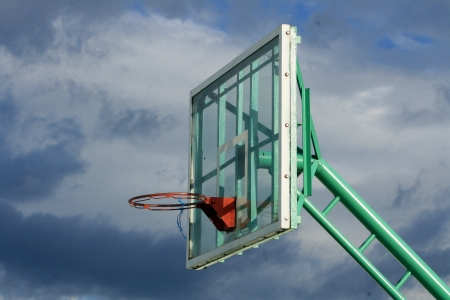 A basketball rim with no net on a glass backboard on an outdoor basketball court in Cotacachi, Ecuadorの写真素材