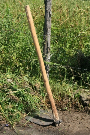 A large hoe leaning against a farmers barbed wire fence in Cotacachi, Ecuadorの写真素材