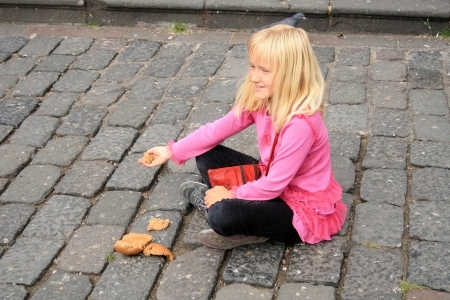 A pretty young blond girl feeding pigeons in a park in Quito, Ecuadorの写真素材