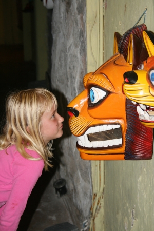 A cute young blond girl staring into the eyes of a carved lion in Quito, Ecuadorの写真素材