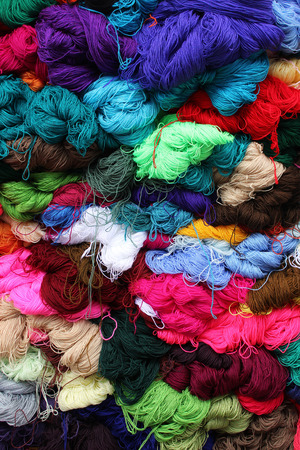 Bundles of yarn in a variety of colors at the outdoor craft market in Otavalo, Ecuadorの写真素材