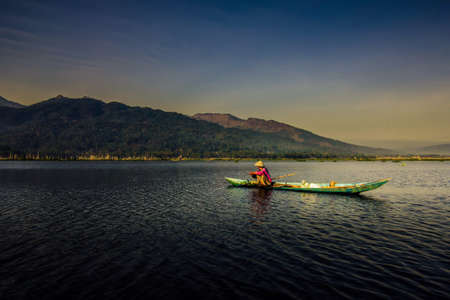 A man fishing with kayak in foggy morningの素材