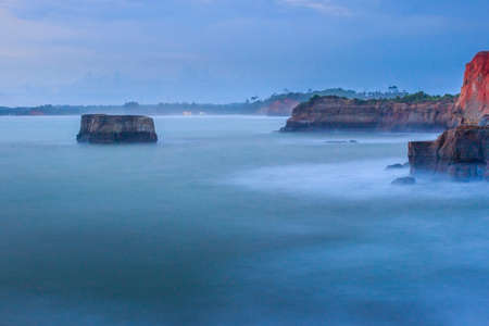 picture of cliff with blue water and golden beach in Indonesia,Bengkulu view from the top view from the top of the mountain. Travel paradise destination for adventure. with the long exposure techniqueの写真素材