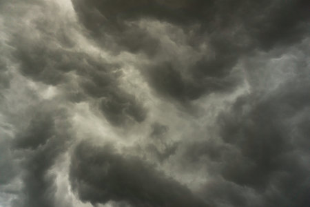 background photo of a stormy sky with rolling clouds and dark black