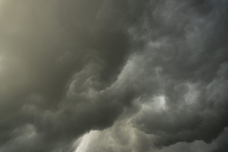 background photo of a stormy sky with rolling clouds and dark black