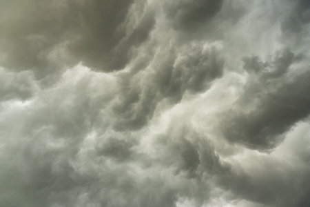 background photo of a stormy sky with rolling clouds and dark blackの写真素材