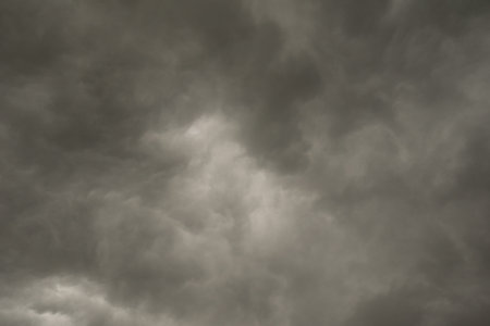 background photo of a stormy sky with rolling clouds and dark black