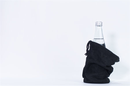 Minimalist Water Bottle in Black Fabric Bag on White Backgroundの写真素材