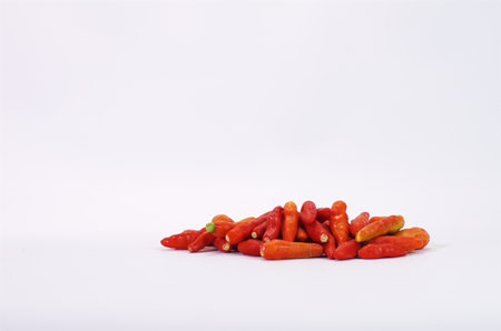 Pile of Vibrant Red Chili Peppers on a White Backgroundの写真素材