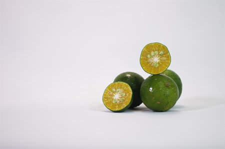 Fresh Green Limes with Sliced Halves Showcasing Juicy Citrusy Textureの写真素材