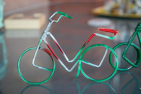 Little toy bicycle made of wire colored like Italian flag - green, white and red color.の写真素材