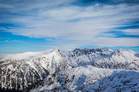 Great View On The Snowy Mountain Peaks and beautiful blue cloudy sky.の写真素材