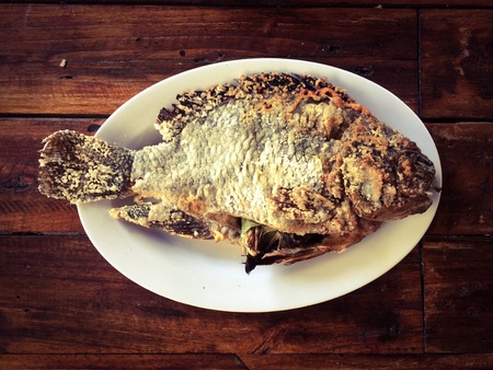 Grilled Fish is a famous seafood dish put on a wooden table with copy spaceの素材