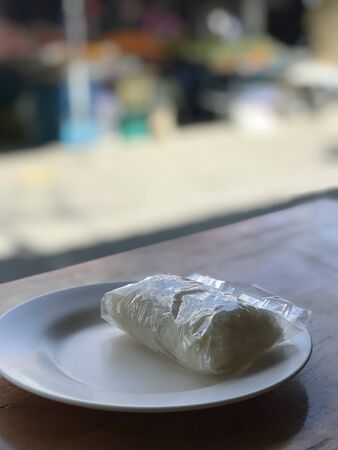 Bag of sticky rice placed on a plate waiting to be eaten with minced meat and papaya salad, northeastern foodの写真素材