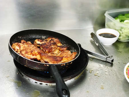 Pan-fried chicken frying on the stove, food and cooking menus.の写真素材