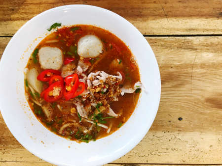 Tom Yum Noodles with Braised Pork in Cups, Place on a Wooden Floor with copy spaceの写真素材