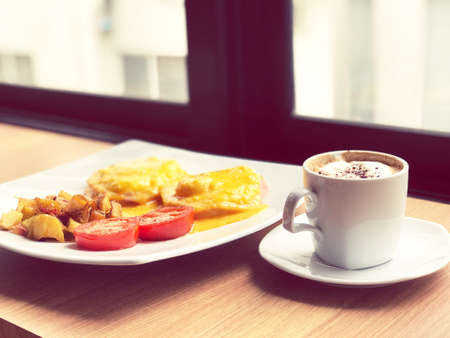 Breakfast made with eggs and chips, laid out and decorated with red tomatoes for breakfast with hot...
