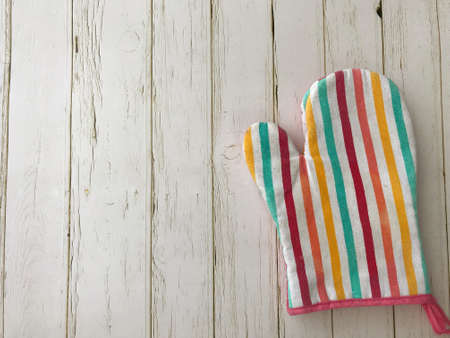Top view of a heat protection gloves on an old white wooden background vintage style with copy spaceの写真素材