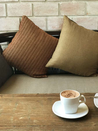 A mug of hot chocolate is placed on the table in the cafe, giving it a warm atmosphereの写真素材