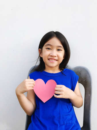 short haired girl wearing a blue dress holding a heart-shaped paper, showing each poseの写真素材