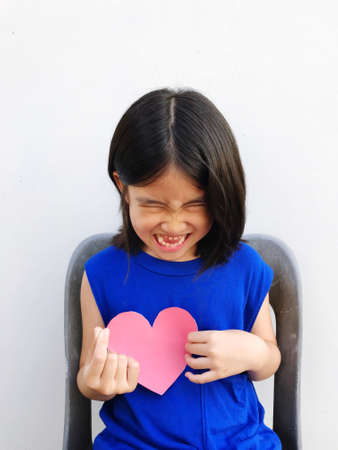 short haired girl wearing a blue dress holding a heart-shaped paper, showing each poseの写真素材