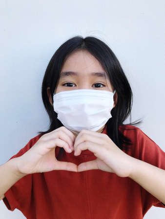 6 year old girl wearing a white mask, protects against coronavirus or COVID-19の写真素材